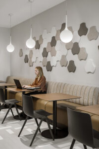 Woman working in a business lounge designs by Acacia